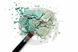 Professional make-up brush on crushed eyeshadows over the white background. Make up artist, beauty salon, beauty blog