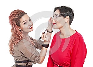 Professional makeup artist making makeup to a model isolated