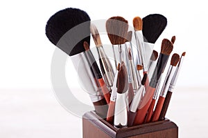 Professional makeup brush on white wooden background