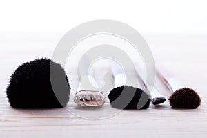 Professional makeup brush on white wooden background