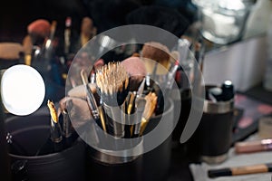 Professional makeup brushes set closeup near salon mirror.