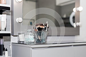 Professional makeup brushes set closeup near salon mirror. Brush any size for professional make-up artist on blur