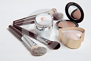 Professional makeup tools on white wooden background.