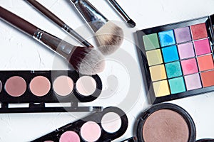 Professional makeup tools on white wooden background.