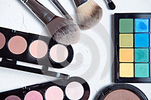 Professional makeup tools on white wooden background.