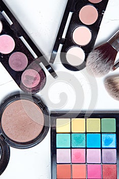 Professional makeup tools on white wooden background.