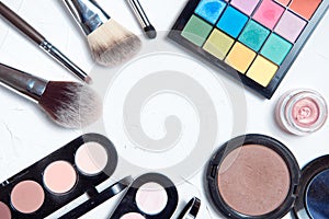 Professional makeup tools on white wooden background.