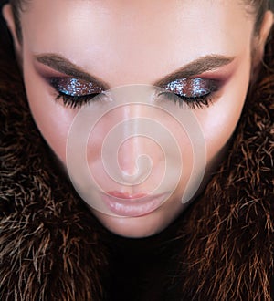 Professional makeup using highlighter and shiny eyeshadows.