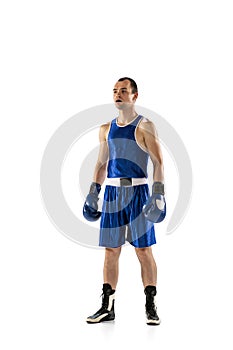 Professional male boxer in blue uniform and boxing gloves isolated on white studio background. Sports emotions, strength