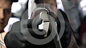 A professional male boy master of ceramics of a car puts ceramics on a car using a fiber sponge rag in a puller, safety goggle