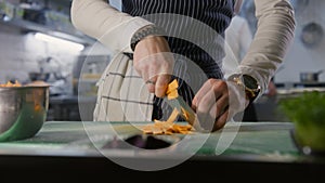 Professional male chef cutting sweet potato