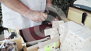 Professional male cutting a white marble piece by a sharp metal knife on a table