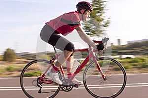 Professional Male Cyclist in Racing Outfit During a Ride on Bike Outdoors.