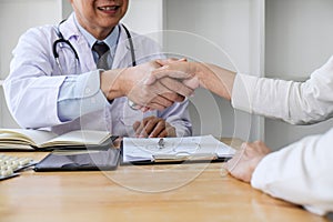 Professional Male doctor in white coat shaking hand with female patient after successful recommend treatment methods, Medicine and