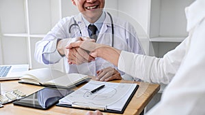 Professional Male doctor in white coat shaking hand with female patient after successful recommend treatment methods, Medicine and