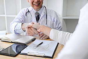 Professional Male doctor in white coat shaking hand with female patient after successful recommend treatment methods, Medicine and