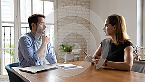 Professional male employer holding job interview with female job seeker.