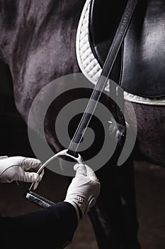 Jockey prepearing horse for the equestrian ride