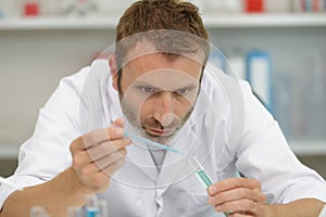 Professional male laboratorian working with pipette
