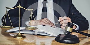 Professional Male lawyer or judge working with contract papers, documents and gavel and Scales of justice on table in courtroom,