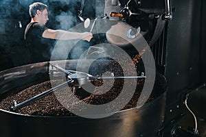 Professional male roaster loading container of steaming machine