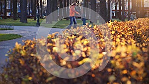 A professional male roller blader performs cool tricks and dances on roller skates in a comfortable city park in the