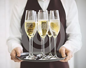 Professional male waiter in uniform serving champagne. DOF.