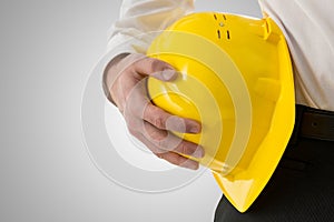 Professional man carrying a yellow hardhat