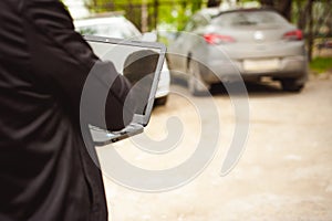 Professional man with a laptop in car tunes tuning control system