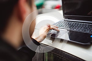 Professional man with a laptop in car tunes tuning control system, updating software, gaining access through to computer