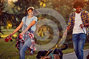 Professional man and woman dog walkers with dog enjoying in park