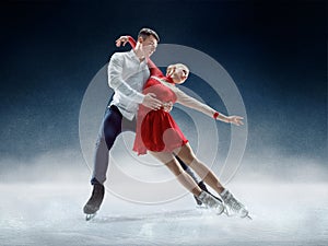 Professional man and woman figure skaters performing on ice show
