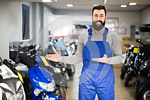 professional man worker displaying various motorcycles in workshop