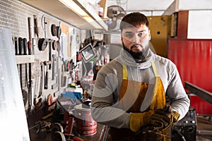 Professional man worker during work with steel in workshop