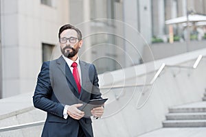 Professional manager looking away with a tablet in hands