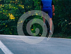 Professional marathon cyclist wearing all of his safety gear rides his bike in the green nature