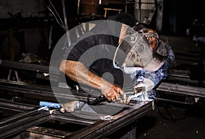 Professional mask protected welder man working on metal weldingProfessional mask protected welder man working on metal welding.