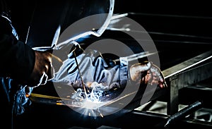 Professional mask protected welder man working on metal welding. Selective Focus