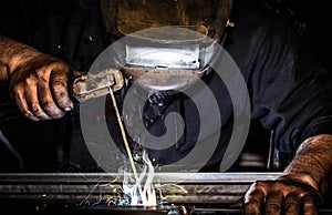 Professional mask protected welder man working on metal welding and sparks metal