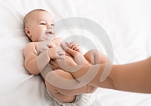 Professional masseur doing massage to newborn baby