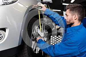 Professional mechanic adjusting automobile wheel alignment