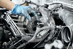 Professional mechanic checking nozzle in diesel car engine