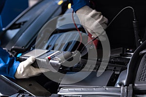 Professional mechanic examining car engine