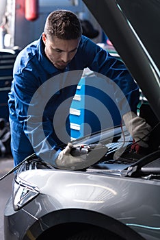 Professional mechanic examining engine