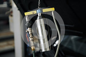 Professional mechanic testing diesel injector in his workshop.