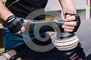 Professional mechanic using a polisher to shine a car photo