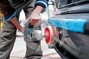 Professional mechanic using a power buffer machine for cleaning