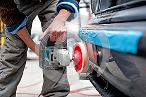 Professional mechanic using a power buffer machine for cleaning photo