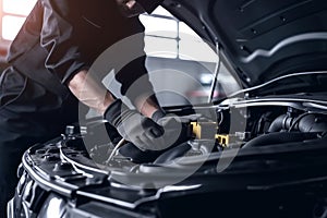 Professional mechanic working on the engine of the car in the garage. Car repair service. Ai generative