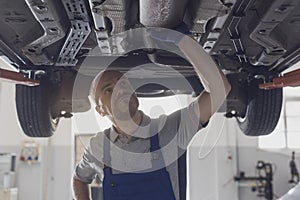 Professional mechanic working under a car